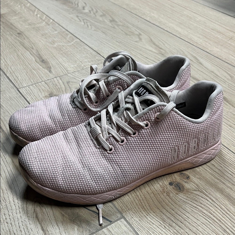 Nobull Trainers In A Light Pink Color With White Branding On The Side.